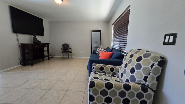 living area featuring baseboards and light tile patterned floors