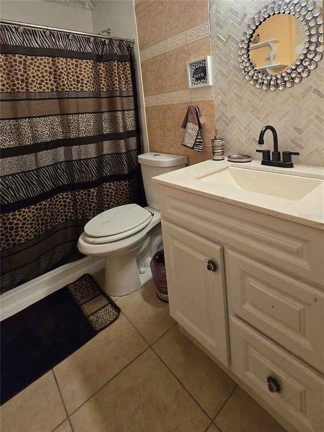 full bath featuring tile walls, backsplash, toilet, vanity, and tile patterned flooring