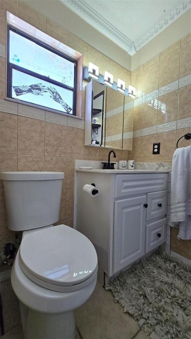 bathroom featuring toilet, vanity, tile walls, and crown molding