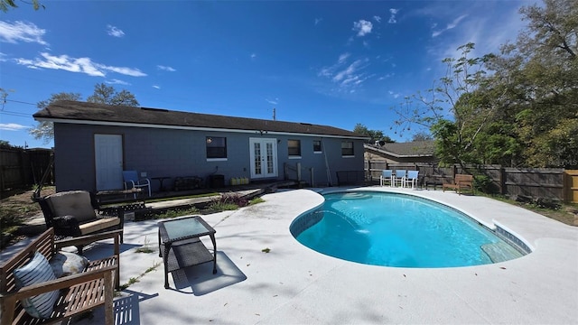 view of pool featuring a patio, french doors, a fenced backyard, and a fenced in pool