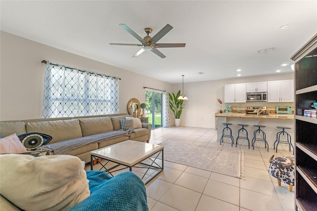 living area featuring a ceiling fan, recessed lighting, a toaster, and light tile patterned floors