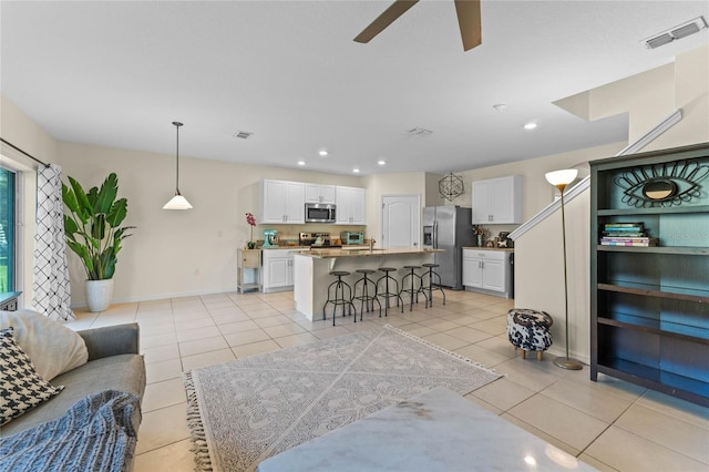 living room featuring recessed lighting, visible vents, and light tile patterned flooring