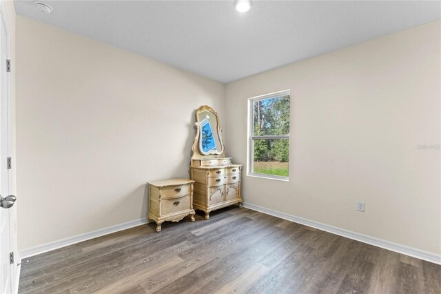 unfurnished bedroom with baseboards and wood finished floors