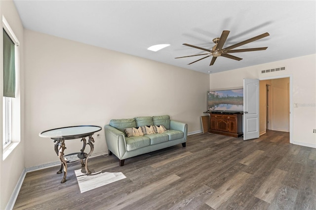 living area with dark wood-style floors, baseboards, and visible vents