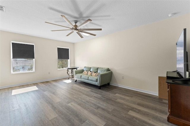 interior space featuring ceiling fan, dark wood-type flooring, visible vents, and baseboards