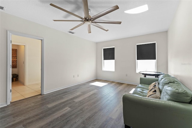 living area featuring ceiling fan, wood finished floors, visible vents, and baseboards