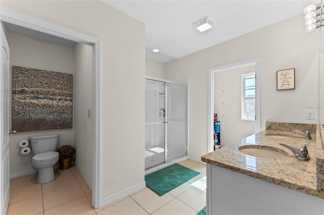 full bathroom with double vanity, a stall shower, toilet, tile patterned flooring, and a sink