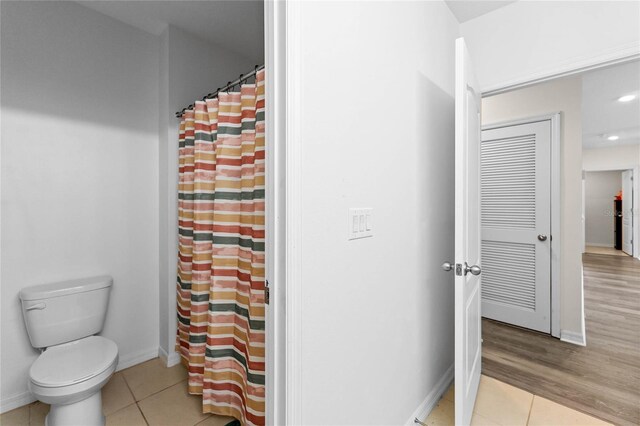 bathroom with curtained shower, toilet, recessed lighting, baseboards, and tile patterned floors