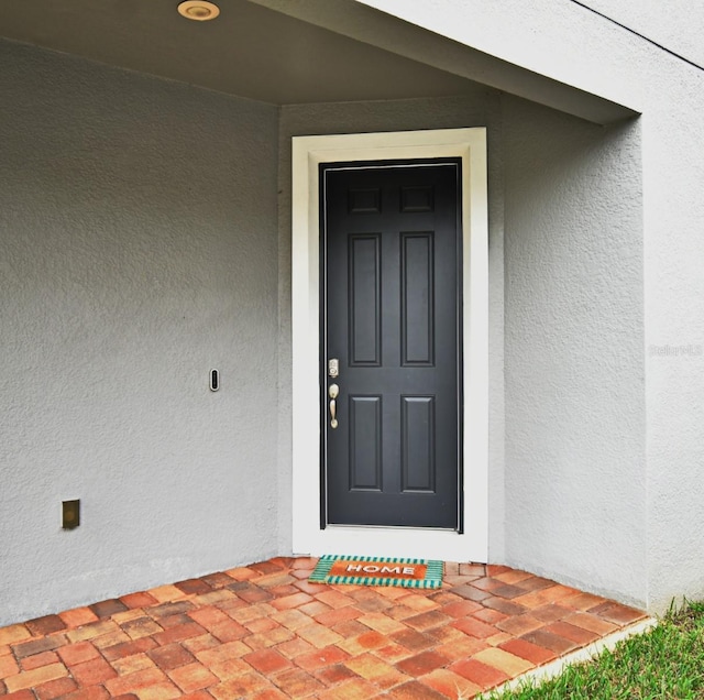 entrance to property with stucco siding