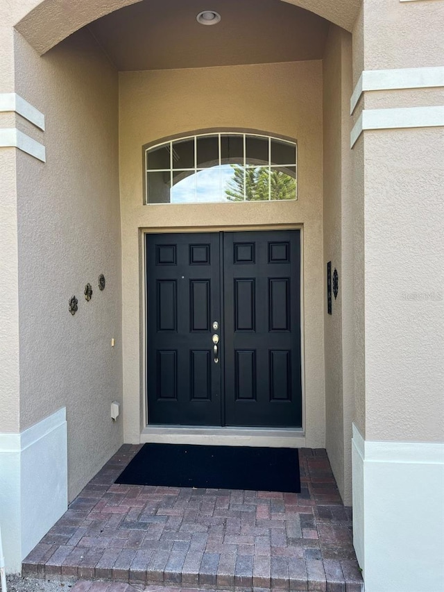 view of exterior entry with stucco siding