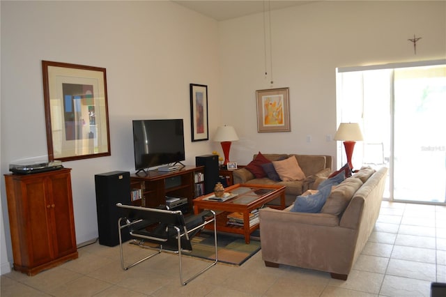 living room with light tile patterned floors and a high ceiling