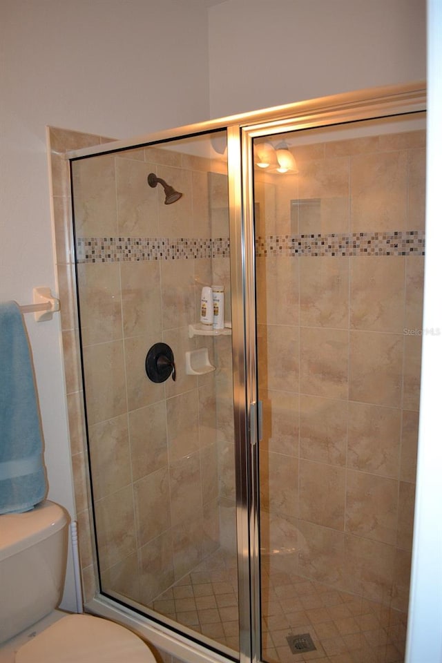 bathroom featuring a stall shower and toilet