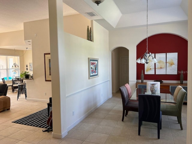 dining area with a chandelier, high vaulted ceiling, light tile patterned floors, visible vents, and baseboards