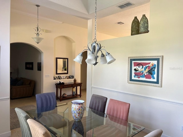 dining space featuring a chandelier, arched walkways, tile patterned flooring, and visible vents