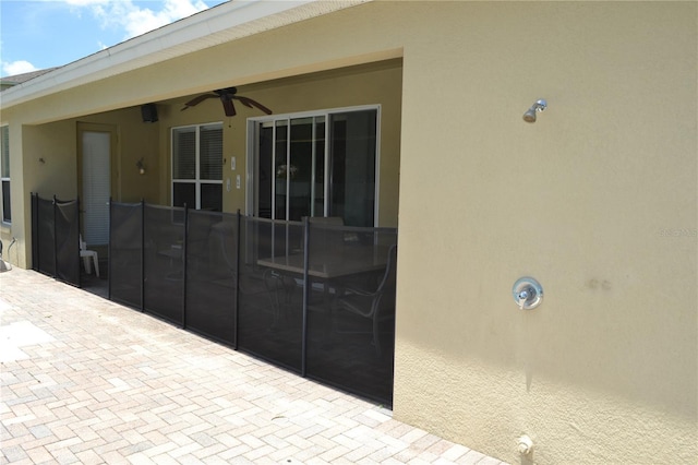 exterior space with a patio area, ceiling fan, and stucco siding