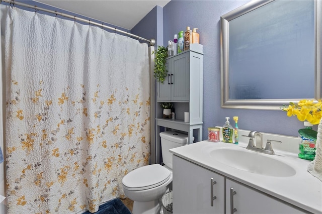 full bathroom featuring a shower with shower curtain, a textured wall, vanity, and toilet