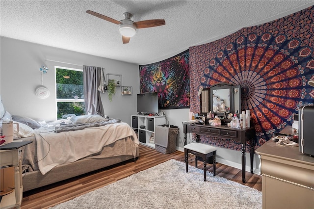 bedroom featuring a textured ceiling, a ceiling fan, and wood finished floors