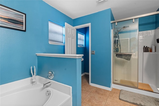 bathroom featuring a garden tub, a stall shower, tile patterned flooring, and baseboards