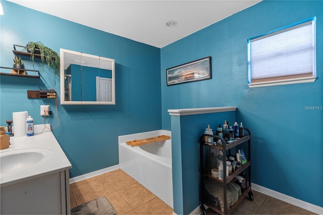 full bath featuring tile patterned flooring, vanity, baseboards, and a bath