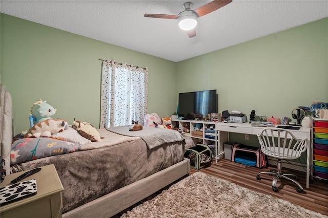 bedroom with a textured ceiling, ceiling fan, and wood finished floors