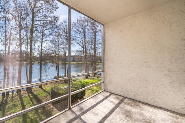 unfurnished sunroom featuring a water view