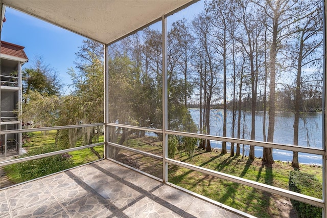 unfurnished sunroom featuring a water view