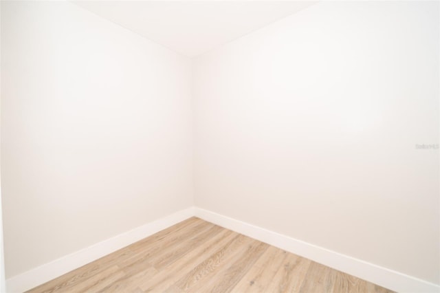 unfurnished room with light wood finished floors and baseboards