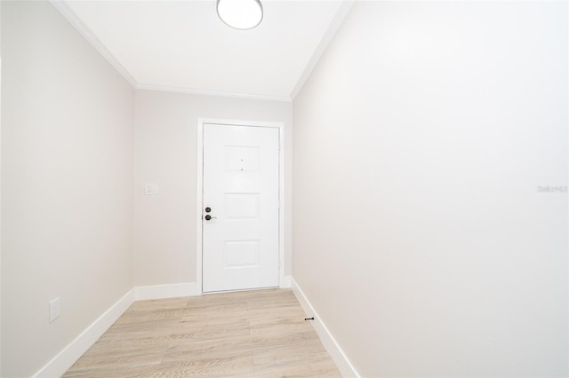 doorway with ornamental molding, light wood-type flooring, and baseboards