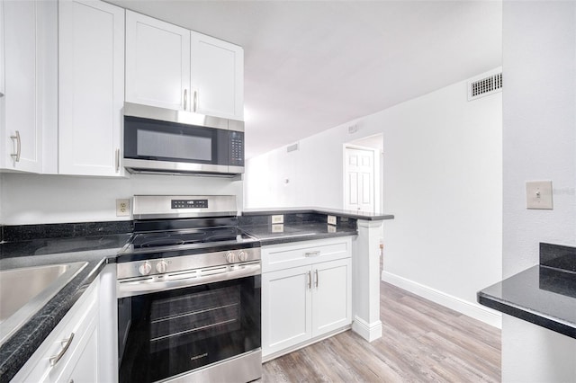 kitchen featuring visible vents, white cabinetry, stainless steel appliances, and light wood-type flooring