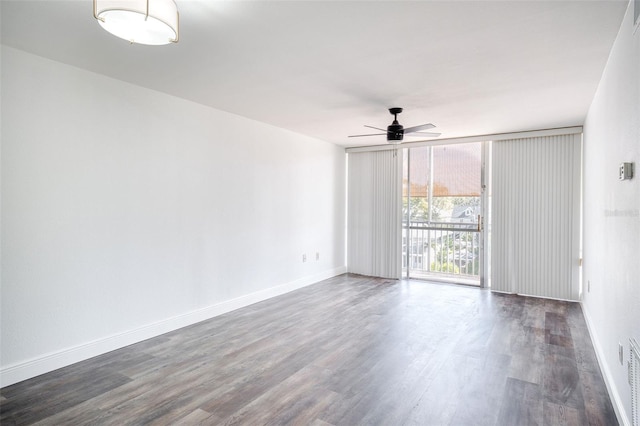 spare room with dark wood-type flooring, floor to ceiling windows, baseboards, and ceiling fan