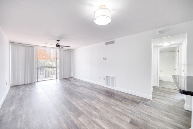 unfurnished room with visible vents, baseboards, and wood finished floors