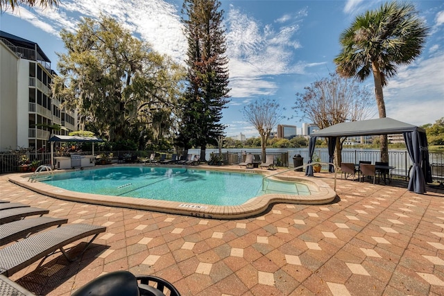 pool with a gazebo, a patio, and fence