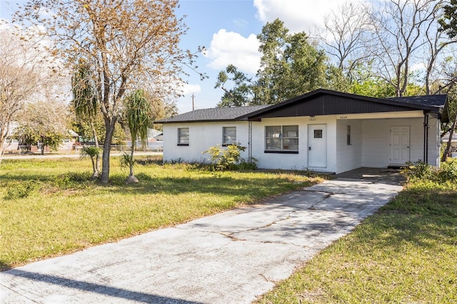 ranch-style home with a carport, driveway, a front lawn, and brick siding