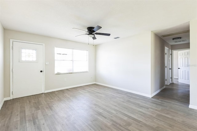 foyer entrance featuring visible vents, wood finished floors, a ceiling fan, and baseboards