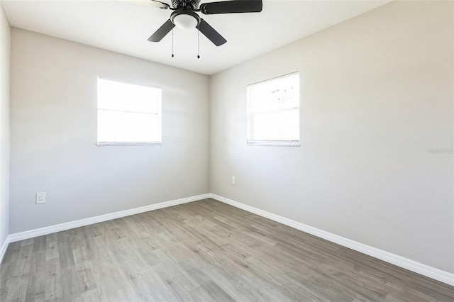 unfurnished room featuring light wood-style floors, baseboards, and a wealth of natural light