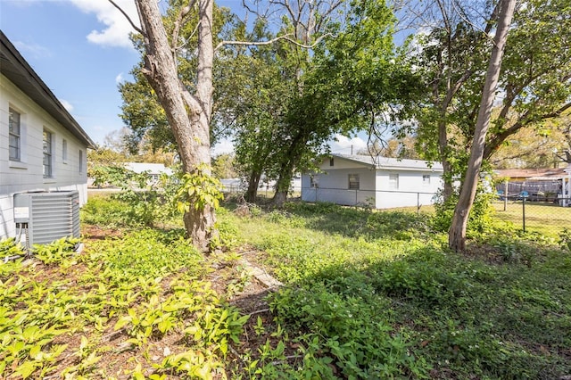 view of yard featuring fence and central air condition unit