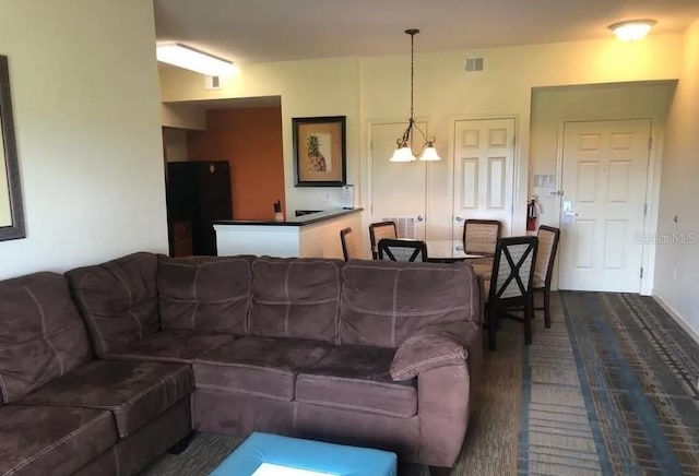 living area with visible vents and dark carpet