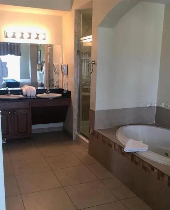 full bathroom with a stall shower, tile patterned flooring, vanity, and a bath