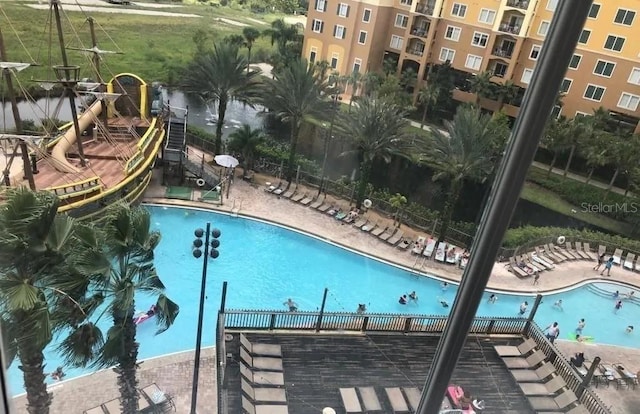 community pool with a patio and fence