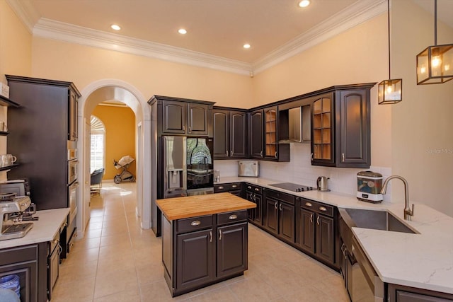 1704 Kersley Cir, Lake Mary, FL 32746 - kitchen with arched walkways, butcher block counters, backsplash, appliances with stainless steel finishes, and wall chimney range hood