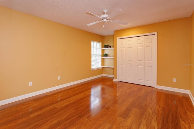 1704 Kersley Cir, Lake Mary, FL 32746 - unfurnished bedroom featuring baseboards, a ceiling fan, wood finished floors, a textured ceiling, and a closet