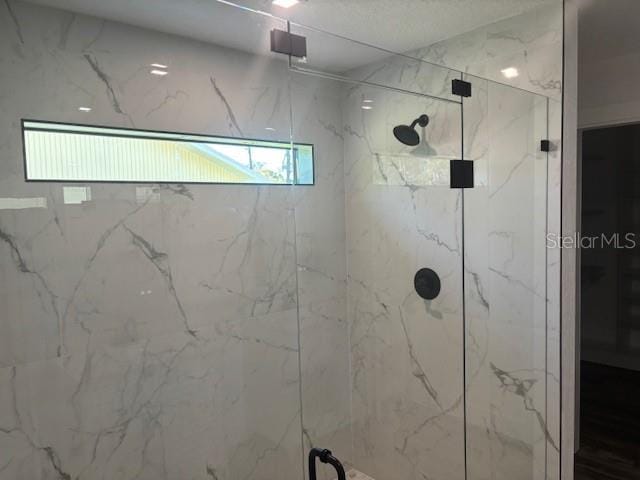 full bath featuring a marble finish shower