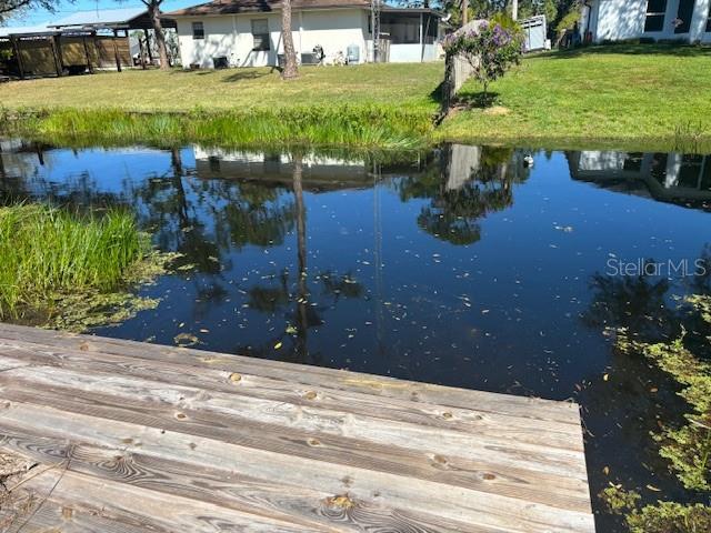 view of dock featuring a water view and a yard