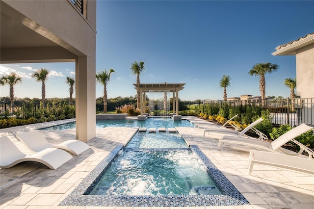 view of pool featuring a patio area, a pool with connected hot tub, fence, and a pergola