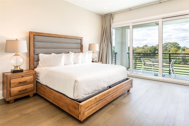 bedroom with access to outside and wood finished floors