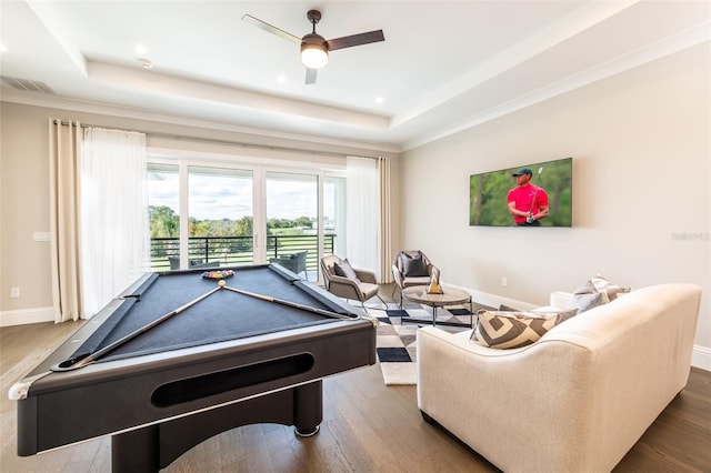 playroom with dark wood-type flooring, a tray ceiling, visible vents, and baseboards