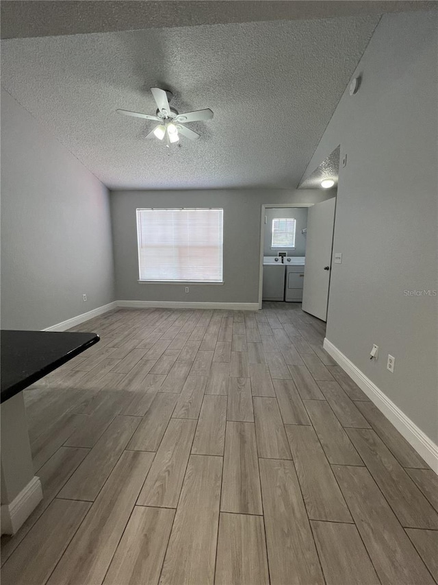 unfurnished living room featuring a sink, ceiling fan, a textured ceiling, wood finished floors, and baseboards