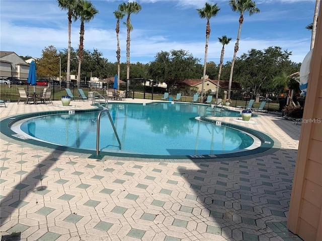 community pool featuring fence and a patio