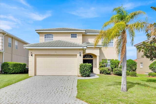 view of front of property featuring a front lawn, decorative driveway, a tile roof, and an attached garage