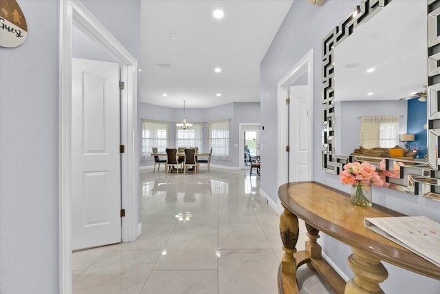 hallway with marble finish floor, baseboards, a chandelier, and recessed lighting